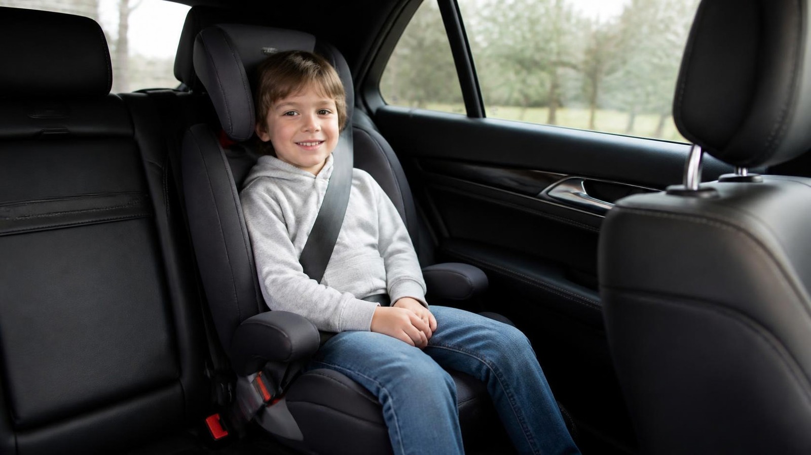 Child in a booster seat in a private airport transfer car