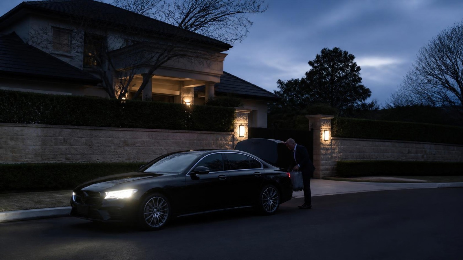 Black sedan collecting a traveller before dawn for an early morning airport transfer