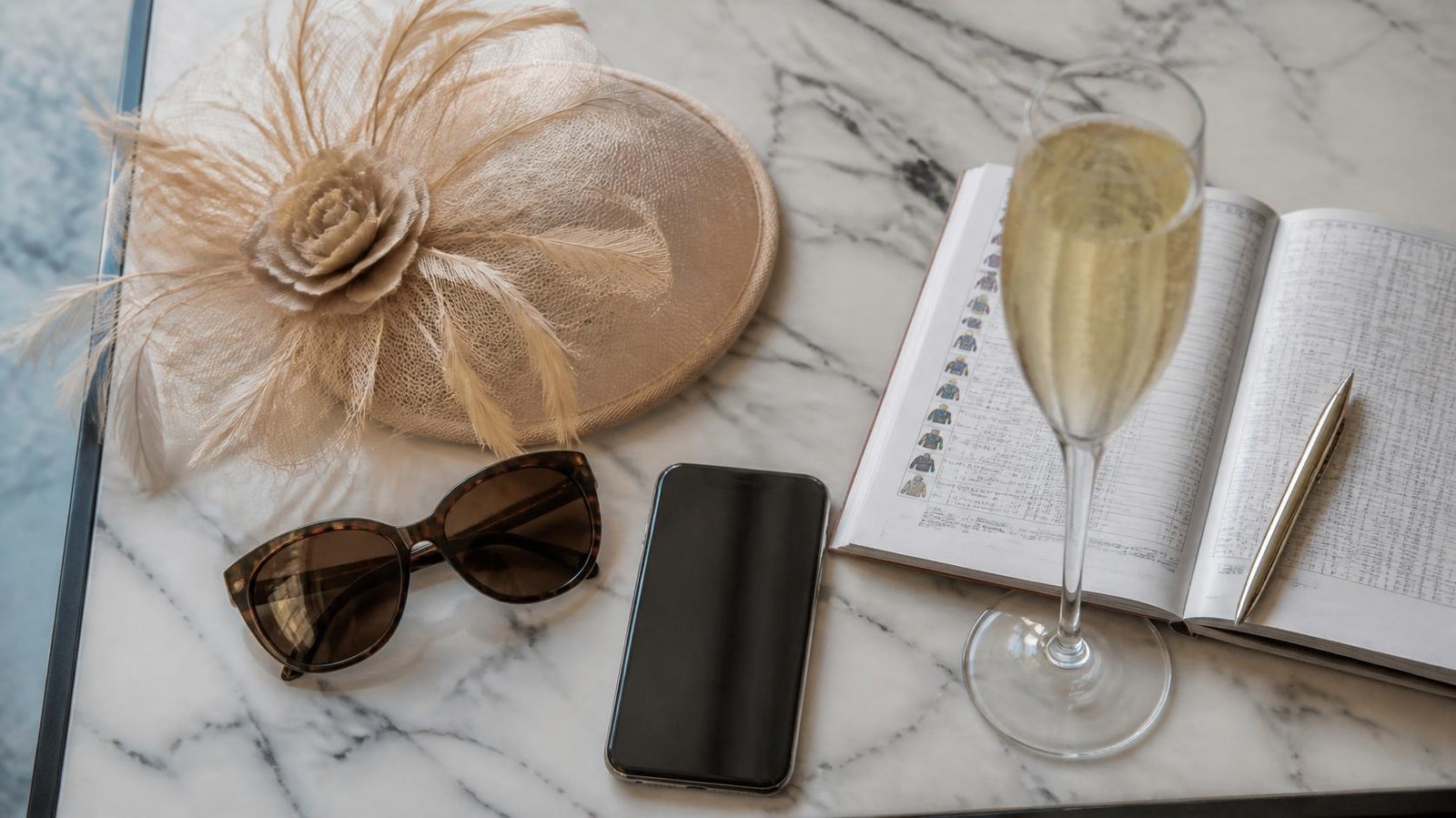 Race day essentials: fascinator, sunglasses, phone and race book